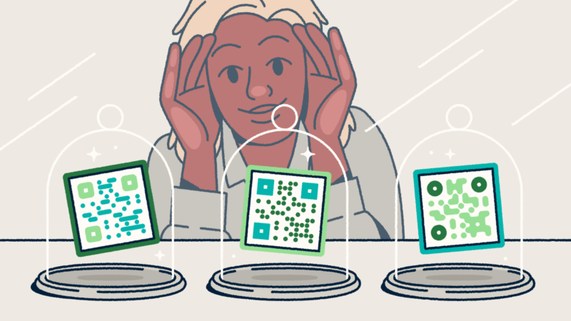 A person looking through a store-front window at three different QR codes on display in glass cloches.