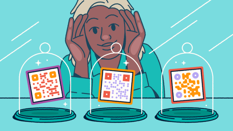 A person looking through a store-front window at three different QR codes on display in glass cloches.