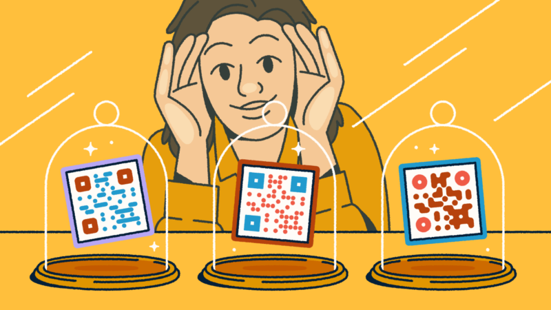 A person looking through a store-front window at three different QR codes on display in glass cloches.