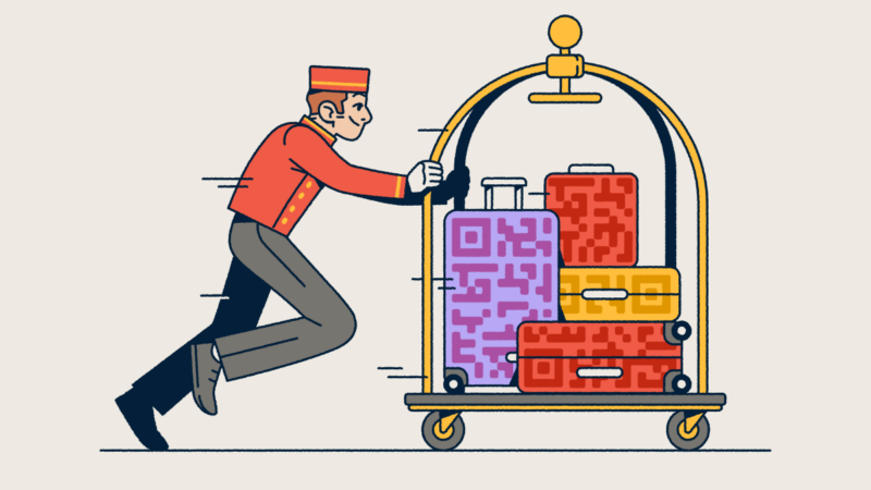 A bellhop pushing a luggage cart with several suitcases that have QR Code prints on them.