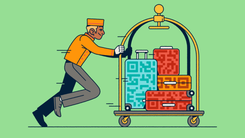A bellhop pushing a luggage cart with several suitcases that have QR Code prints on them.